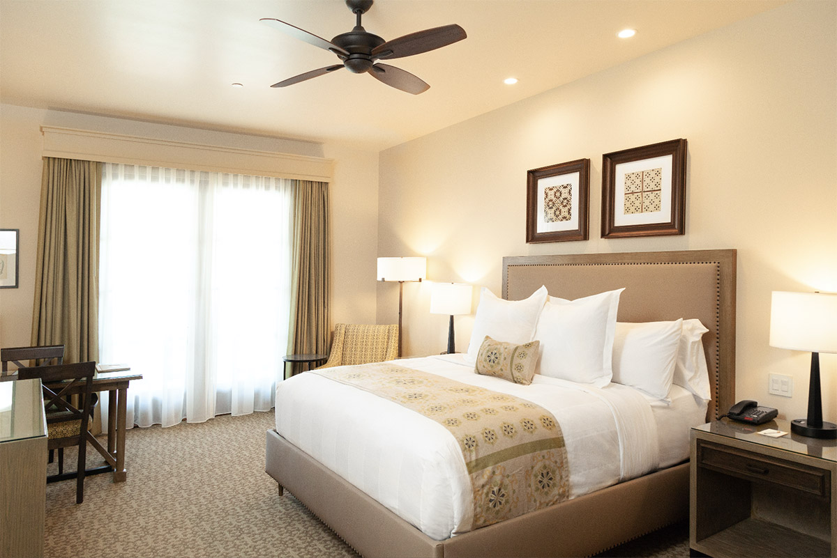 King Deluxe Room, showing a bed, chair, fan, and table
