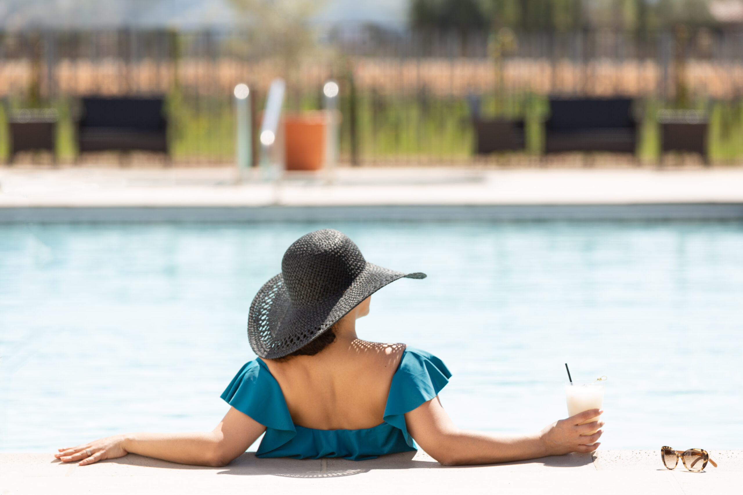 the pool at Ponte Vineyard Inn, woman from behind holding her cocktail