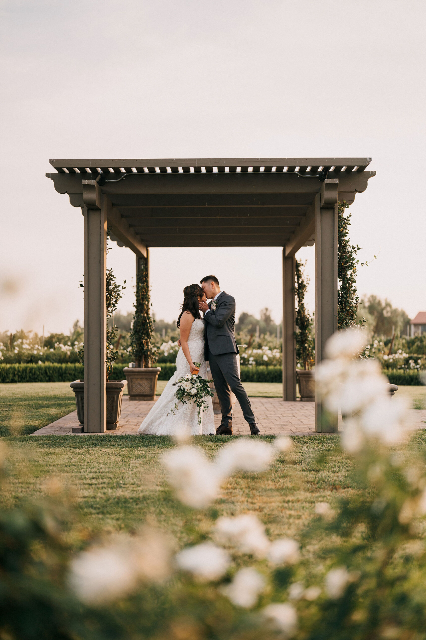 couple kissing under the ceremony arch
