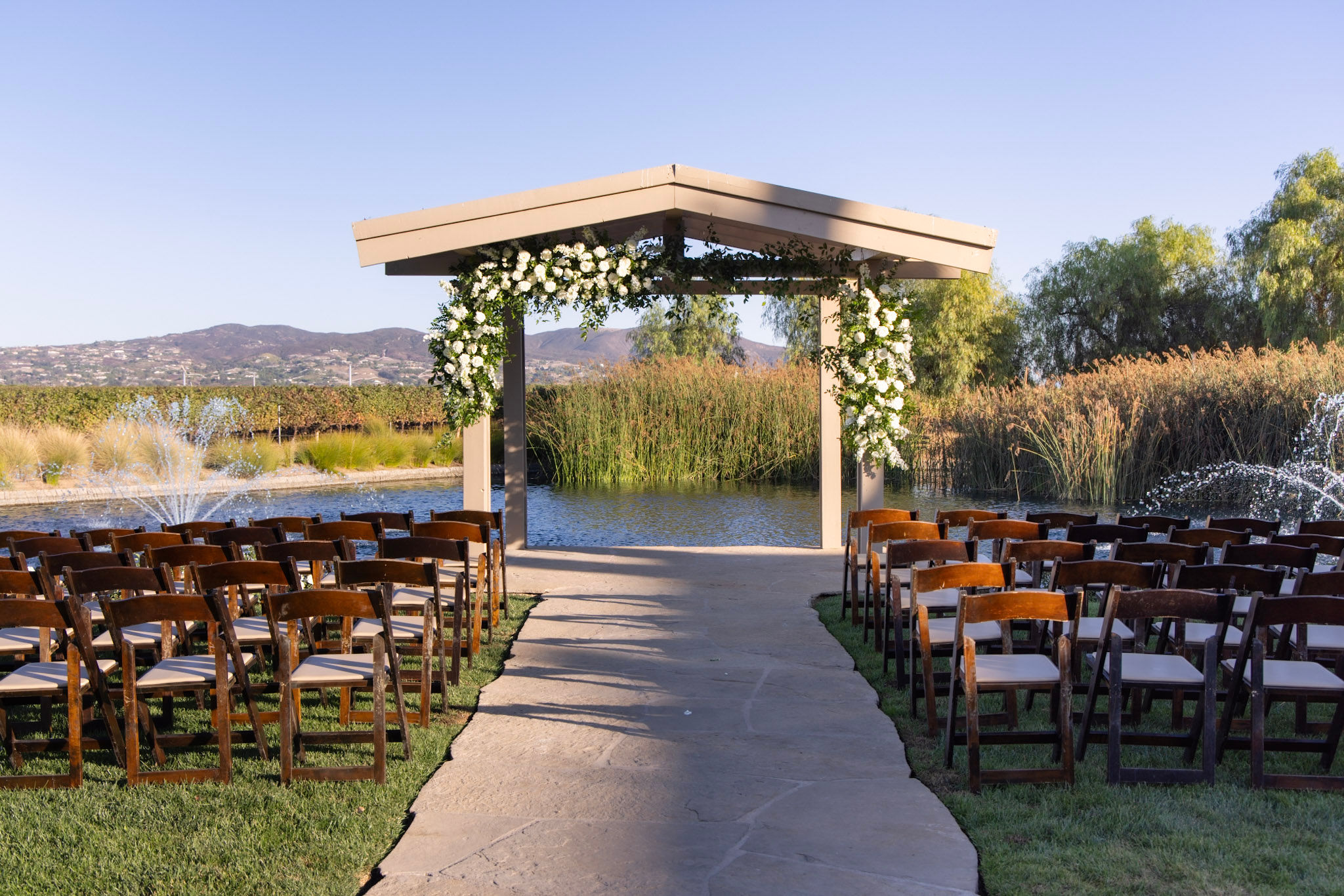 Ceremony site with floral, seating, and the pond