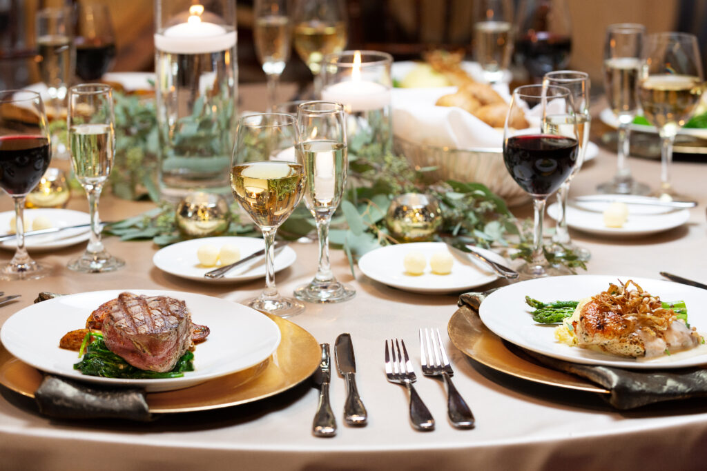 Dinner setting with steak and lobster with two glasses of red and white wine