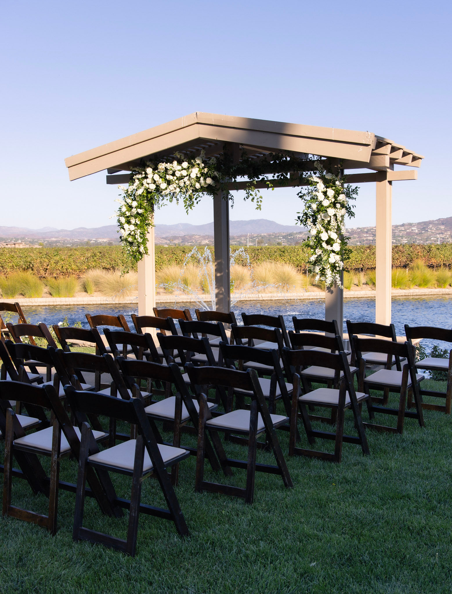 Ceremony site with floral, seating, and the pond