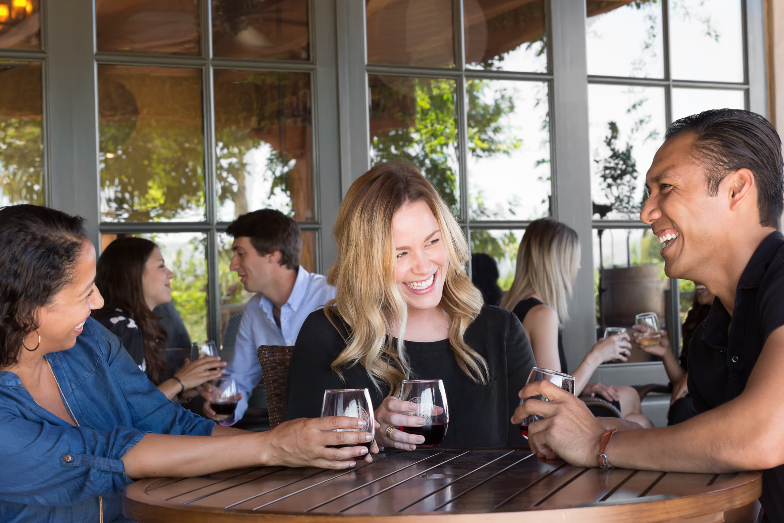 3 people smiling and enjoying wine
